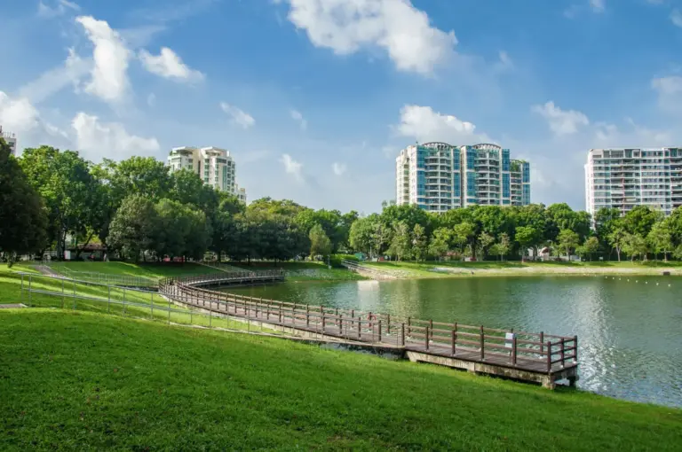 A wide-angle view of the Bedok heartlands, showing a mix of modern HDB blocks and lush park spaces, a community known for its legendary hawker centers and late-night eats.