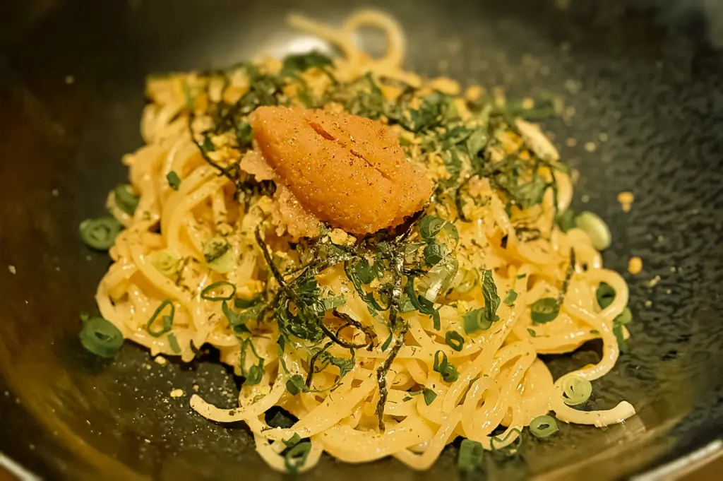 Close-up angled shot of mentaiko pasta with mentaiko butter sauce, shredded nori, spring onions, and handmade noodles at Sio Pasta Raffles Place