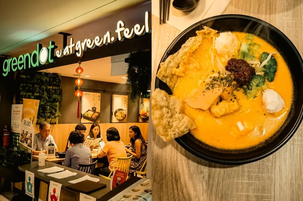 Left: A three-quarter, eye-level view of a restaurant entrance featuring a green illuminated logo sign that reads 'at green feel', with several customers seated at light wood tables inside under warm lighting and a green plant wall panel visible. Right: A top-down, close-up shot of a black ceramic bowl filled with thick orange laksa curry broth, noodles, broccoli florets, a dollop of dark chili paste, a white fishball, and pieces of fried beancurd skin.