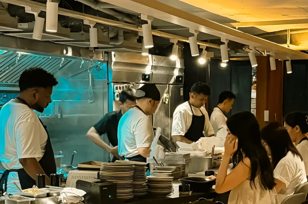 Wide-angle eye-level shot of Sio Pasta Raffles Place open kitchen with chefs preparing handmade pasta and diners at counter seating
