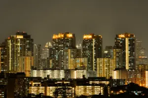 Telephoto night shot of Singapore HDB skyline near Bishan with illuminated apartment blocks, highlighting residential area known for diverse local dining options