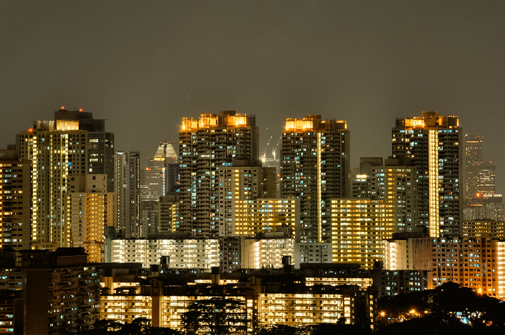 Telephoto night shot of Singapore HDB skyline near Bishan with illuminated apartment blocks, highlighting residential area known for diverse local dining options