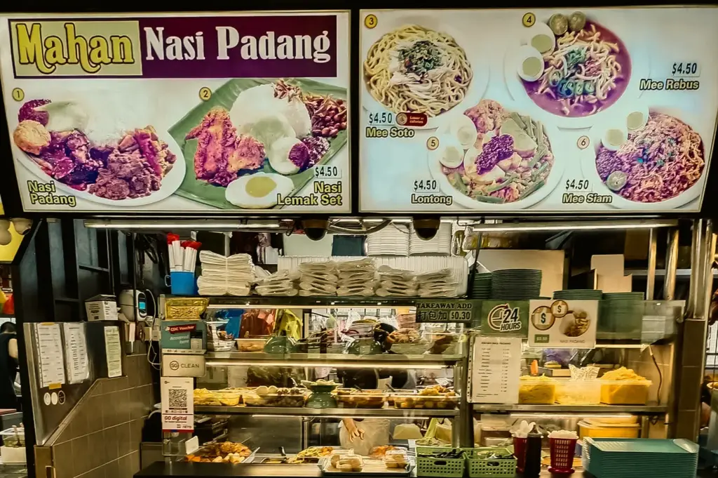 Eye-level front-facing shot of a Nasi Padang hawker stall menu in Singapore featuring Indonesian dishes like mee soto, lontong, and nasi lemak in a Clementi food centre