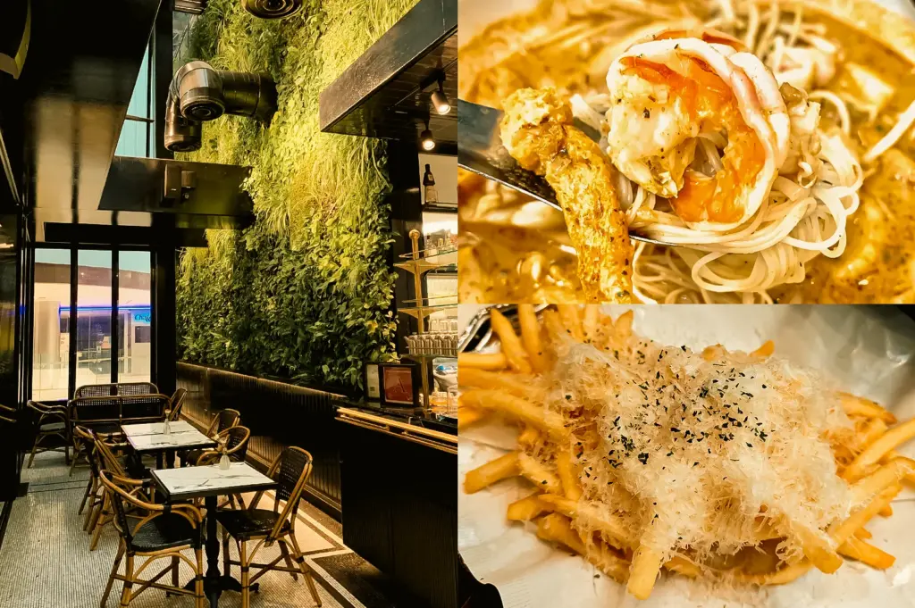 “Left: Wide-angle eye-level view of a contemporary café interior featuring marble-topped tables, woven chairs, dark architectural elements, a vertical living plant wall, exposed ducts, and warm accent lighting creating a modern dining atmosphere. Upper Right: Extreme close-up angle of PS. Crab & Prawn Laksa, showing noodles and a large prawn lifted on a fork above a creamy orange broth, emphasizing the glossy sauce and seafood textures. Lower Right: Close-up top-down view of PS. Truffle Shoestring Fries piled on a plate and generously topped with finely grated cheese and herb seasoning, highlighting crisp fries, delicate shavings, and layered textures.”