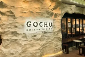 Wide angle shot of Gochu Korean Dining cave-themed restaurant entrance with textured stone walls at Orchid Country Club Singapore