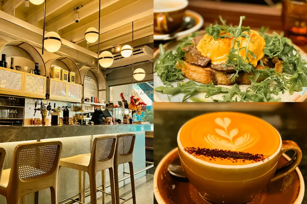 Left: wide-angle eye-level shot of a stylish café counter area with woven bar stools, marble countertop, arched shelving, hanging globe lights, and neatly displayed cups and coffee equipment under warm lighting; Upper Right: close-up three-quarter shot of a plated brunch dish featuring toast layered with meat, greens, and a poached egg drizzled with sauce on a ceramic plate; Lower Right: close-up eye-level shot of a latte in a beige cup with leaf-pattern latte art and a dusting of cocoa powder, placed on a saucer in a softly lit café setting.