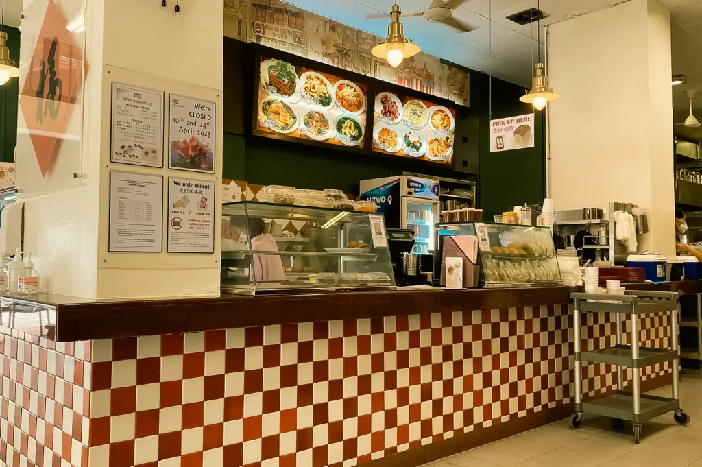 YY Kafei Dian Singapore kopitiam interior with traditional food counter, menu boards and display case, eye-level wide interior shot angle