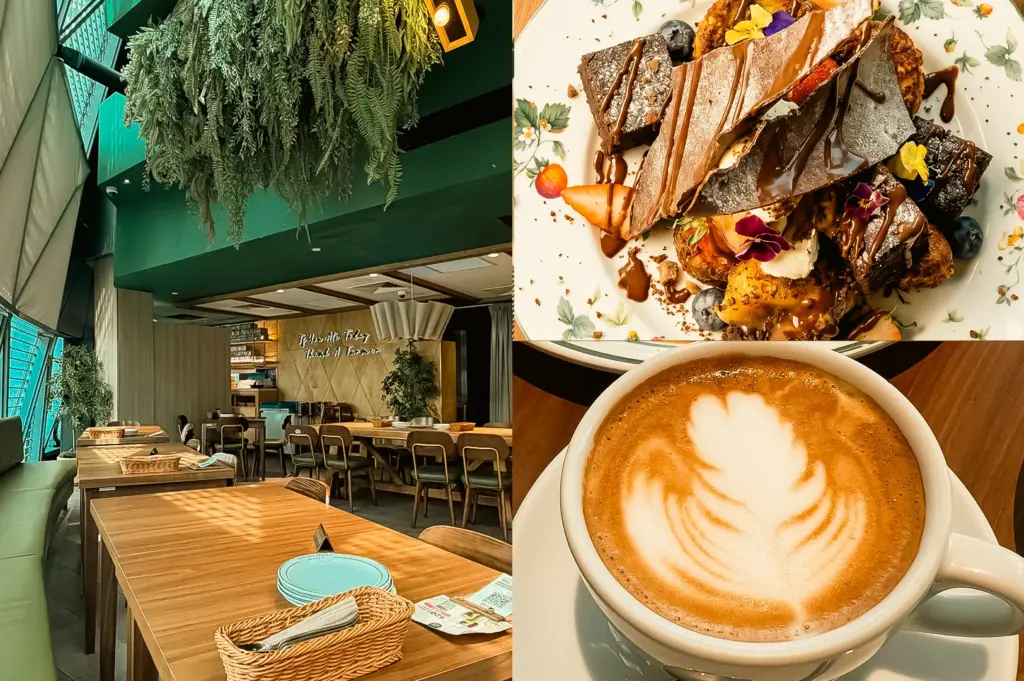 Left: wide-angle eye-level shot of a café dining area with long wooden tables, upholstered chairs, large windows, and hanging greenery cascading from the ceiling, illuminated by natural light; Upper Right: top-down close-up of a dessert platter with sliced chocolate cake, strawberries, blueberries, edible flowers, and chocolate drizzle arranged on a decorative plate; Lower Right: close-up eye-level shot of a latte in a white cup featuring symmetrical leaf latte art, placed on a wooden table under warm lighting.