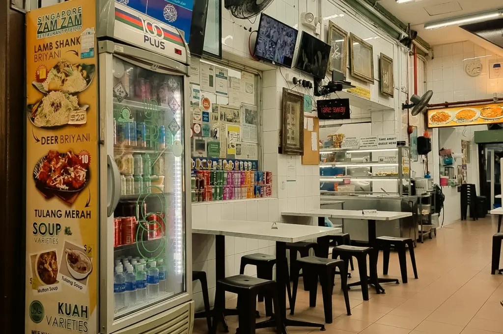 Eye-level wide-angle view of the dining area inside Singapore Zam Zam Restaurant, a historic halal Indian Muslim eatery on North Bridge Road serving murtabak, nasi briyani and traditional Singapore dishes.